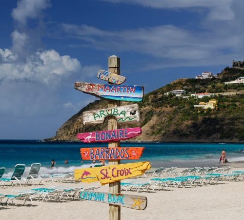 Signpost of Caribbean islands on the beach at St Maarten